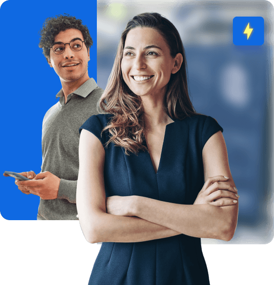 A smiling woman crossing her arms in front of a man holding his phone.