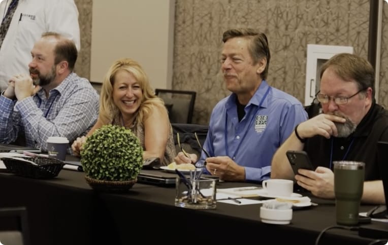 Radian Research employees laughing at a table together.