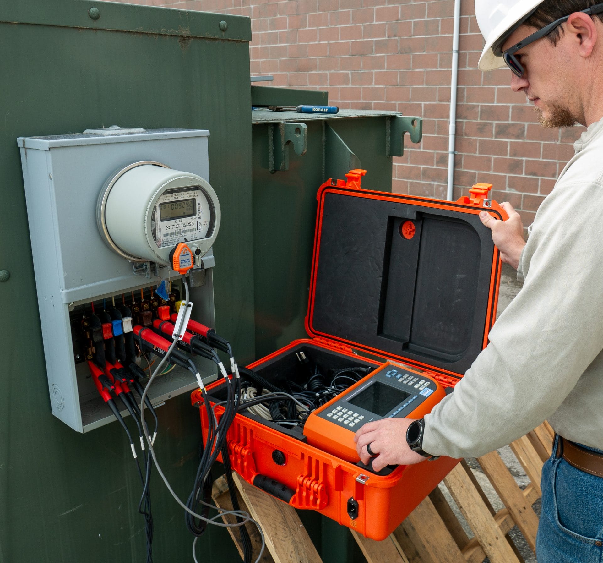 A meter technician using the Powermetrix 6618A in the field on a meter.