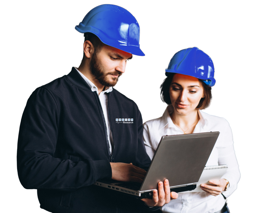 Two Radian Research employees standing using a laptop in blue hardhats.