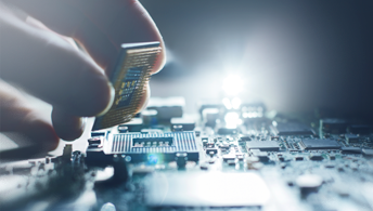 A microchip being added to a board.
